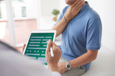 Doctor with a patient, using Prescription Monitoring System from iPad, 