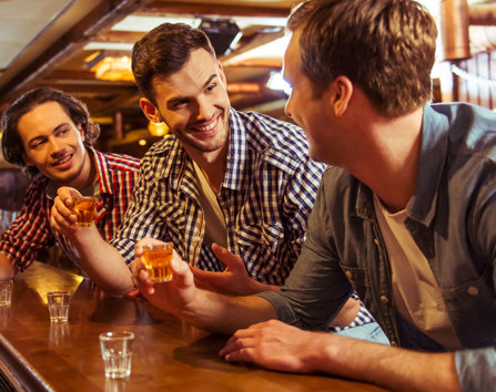 Three men drinking shots of alcohol