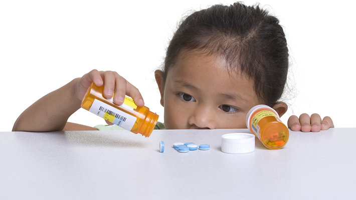 Little girl taking pills.  